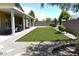 Backyard featuring artificial turf, desert landscaping, and a cozy firepit seating area at 7047 Noble Flair Ct, Las Vegas, NV 89131