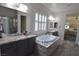 Bright bathroom with granite countertops, dual sinks, and a luxurious tub at 7047 Noble Flair Ct, Las Vegas, NV 89131