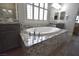 Bathroom featuring soaking tub with granite surround and chrome fixtures at 7047 Noble Flair Ct, Las Vegas, NV 89131