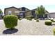 A well-maintained yard with manicured bushes and rock cover surrounding a home with stone accents at 7047 Noble Flair Ct, Las Vegas, NV 89131