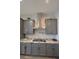 Modern kitchen features grey cabinets, granite countertops, and a stainless steel range hood at 7047 Noble Flair Ct, Las Vegas, NV 89131