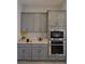Modern kitchen with stainless steel appliances, granite counters, and gray cabinetry at 7047 Noble Flair Ct, Las Vegas, NV 89131
