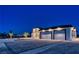 Modern three-car garage home with landscaped front yard at night at 1691 Blackhorn St, Pahrump, NV 89048