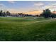 Golf course view with homes in the background and sunset in the sky at 5205 Sandy Cactus Ln, Las Vegas, NV 89149