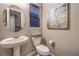 Clean bathroom with pedestal sink, toilet, and decorative framed art at 11712 Emerald Lake Ave, Las Vegas, NV 89138