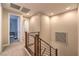 Upstairs hallway with wood railing, neutral walls, and modern art at 11712 Emerald Lake Ave, Las Vegas, NV 89138