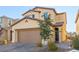 Two-story house with tan siding, brown garage door, and landscaping at 2815 Donatello Manor Pl, Henderson, NV 89044