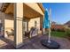 Covered patio with seating area, umbrella, and artificial turf at 2815 Donatello Manor Pl, Henderson, NV 89044