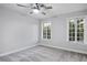 Serene bedroom with plush carpet, two windows with leafy views, and modern ceiling fan for a peaceful retreat at 3531 W Arby Ave, Las Vegas, NV 89118