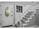 Bright foyer with a decorative front door, staircase with white banister, and natural light at 3531 W Arby Ave, Las Vegas, NV 89118