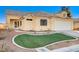 One-story house with tan exterior, landscaped lawn, and attached garage at 6143 Basilone Ave, Las Vegas, NV 89122