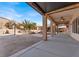 Backyard featuring a covered patio, palm trees, and lush landscaping at 6192 Rocky Top Ave, Las Vegas, NV 89110