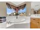 Bathroom with soaking tub under a large window and a vanity at 6192 Rocky Top Ave, Las Vegas, NV 89110