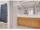 Well-lit bathroom featuring a wood cabinet and a large mirror over the sink at 6192 Rocky Top Ave, Las Vegas, NV 89110