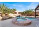 Backyard pool and spa surrounded by lush palm trees and rock features at 6192 Rocky Top Ave, Las Vegas, NV 89110