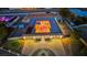 Aerial view of the unique home featuring a central courtyard pool, well-lit driveway, and desert landscaping at 647 Foxhall Rd, Henderson, NV 89002