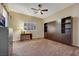 Bedroom featuring a ceiling fan, window, and a built-in cabinet with shelves and storage space at 647 Foxhall Rd, Henderson, NV 89002