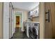 Laundry room with stainless steel washer and dryer, storage shelves, and a sliding barn door at 647 Foxhall Rd, Henderson, NV 89002