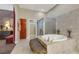 Bright main bathroom with a soaking tub, walk-in shower, and marble tiled wall at 647 Foxhall Rd, Henderson, NV 89002