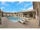 Inviting pool area with an outdoor kitchen and several lounge chairs for sunbathing or relaxing at 647 Foxhall Rd, Henderson, NV 89002