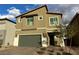 Charming two-story house featuring a green garage door and paved brick driveway at 7156 Woodrow Ranch St, Las Vegas, NV 89166