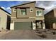 Inviting two-story home with neutral exterior, green garage door and brick driveway at 7156 Woodrow Ranch St, Las Vegas, NV 89166