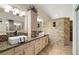 Modern bathroom with double vanity, stone accent wall, and tiled shower at 5200 Wheatland Dr, Pahrump, NV 89061