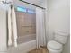 Standard bathroom featuring a shower-tub combo with curtain, toilet, towel bar, and tiled floors, ensuring functionality at 2800 Linkview Dr, Las Vegas, NV 89134