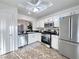 Well-lit kitchen with white cabinets, stainless steel appliances, and durable dark countertops, ready for your culinary adventures at 2800 Linkview Dr, Las Vegas, NV 89134