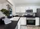 Bright kitchen featuring white cabinetry, sleek black countertops, and stainless steel appliances, perfect for modern living at 2800 Linkview Dr, Las Vegas, NV 89134