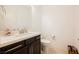 Cozy half bathroom featuring dark wood cabinetry, white walls, and tile flooring at 410 Giocoso Ct, Henderson, NV 89011