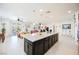 Bright, open kitchen featuring a large island with granite countertop and dark cabinetry at 410 Giocoso Ct, Henderson, NV 89011