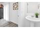 Small powder room with pedestal sink and wood floor at 5266 Sherwood Forest Ln, Las Vegas, NV 89122