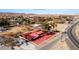 Aerial view of a home with red roof outlined in property lines, mature trees, and desert landscape backdrop at 2925 Rice St, Logandale, NV 89021