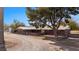 Inviting single-story brick home featuring a metal roof, mature trees, and an oversized driveway at 2925 Rice St, Logandale, NV 89021