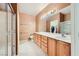 A spacious bathroom features double sinks, wood cabinetry, and a glass enclosed shower at 7804 Island Rail Dr, North Las Vegas, NV 89084