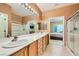 Bright bathroom with double sinks, tiled floors, and a glass-enclosed shower, offering a clean and modern design at 7804 Island Rail Dr, North Las Vegas, NV 89084