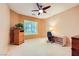 Comfortable bedroom with a ceiling fan, a work space, and a window with plantation shutters for a bright, airy feel at 7804 Island Rail Dr, North Las Vegas, NV 89084