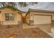 Close-up of a single-story home's exterior showcasing a two-car garage and a well-maintained front yard at 7804 Island Rail Dr, North Las Vegas, NV 89084