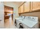 Convenient laundry room with tile flooring, wooden cabinets and modern appliances at 7804 Island Rail Dr, North Las Vegas, NV 89084