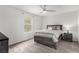 Bedroom with neutral carpet, ceiling fan, window, and wood-look bed frame with stylish bedding at 4490 Rabnor Cir, Las Vegas, NV 89115