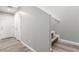 Hallway with gray wood-look floors leading to a staircase and several doors at 4490 Rabnor Cir, Las Vegas, NV 89115