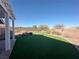 This backyard features a mix of artificial turf, desert landscaping, and a covered patio at 2710 Mustang Pass St, Laughlin, NV 89029