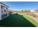 The backyard features desert landscaping with artificial turf and covered patio at 2710 Mustang Pass St, Laughlin, NV 89029