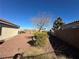 Backyard with desert landscaping, mature trees, and small spotlights near a wall at 2710 Mustang Pass St, Laughlin, NV 89029