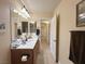 Bright bathroom featuring a dual-sink vanity, neutral wall color, and an illuminated decorative light fixture at 2710 Mustang Pass St, Laughlin, NV 89029