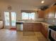 Well-lit kitchen featuring wooden cabinets, a stainless steel dishwasher, and a double door leading to the backyard at 2710 Mustang Pass St, Laughlin, NV 89029