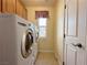 Bright laundry room with front loading washer and dryer and tile floor near door at 2710 Mustang Pass St, Laughlin, NV 89029