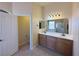 Bathroom featuring dual sinks, a large mirror, and a separate toilet room at 2710 Mustang Pass St, Laughlin, NV 89029