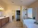 Bright bathroom featuring a tub, glass shower, vanity with dual sinks, and large mirror at 2710 Mustang Pass St, Laughlin, NV 89029